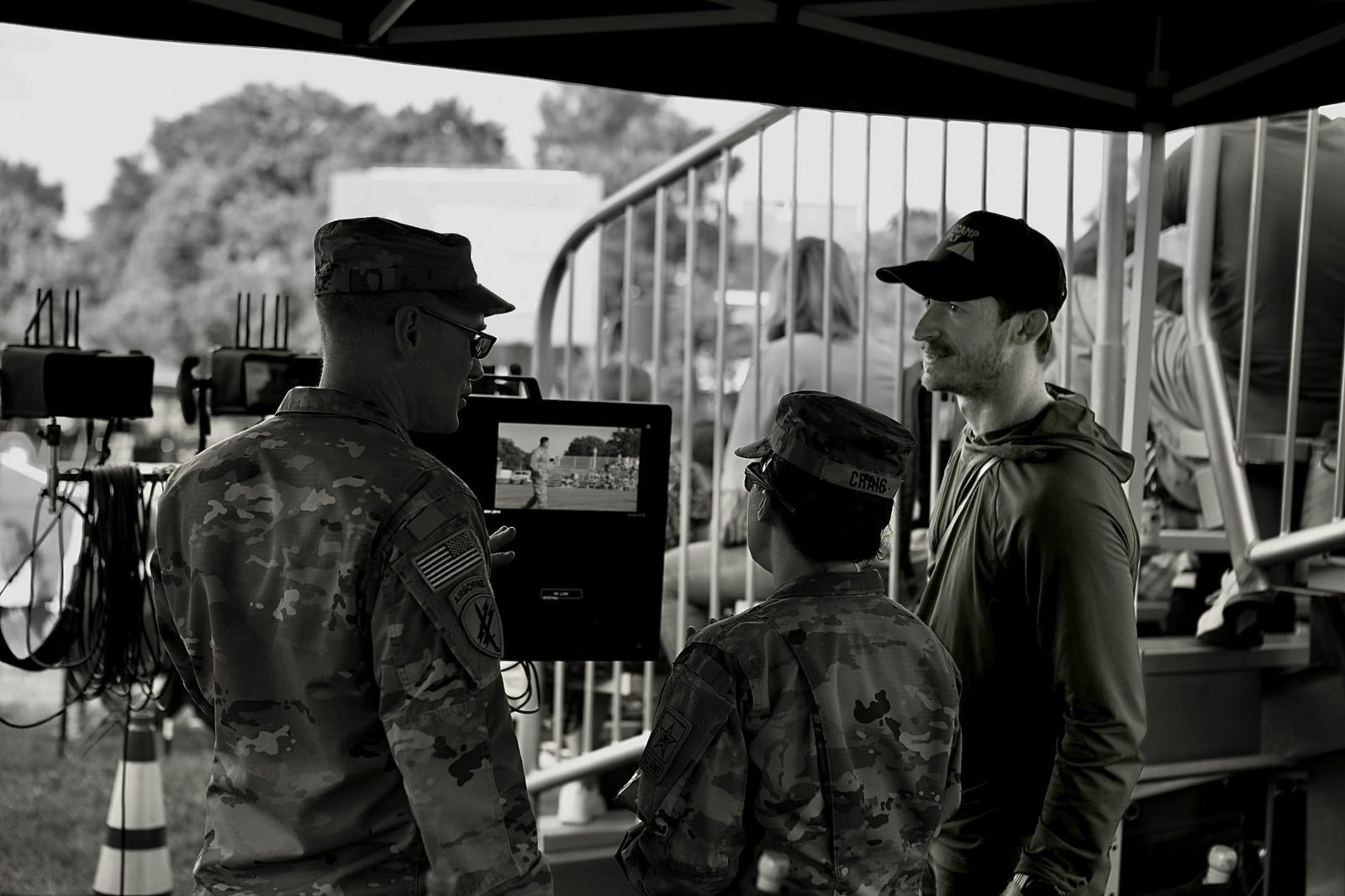 Austin reviewing a shot on a monitor with two soldiers on set